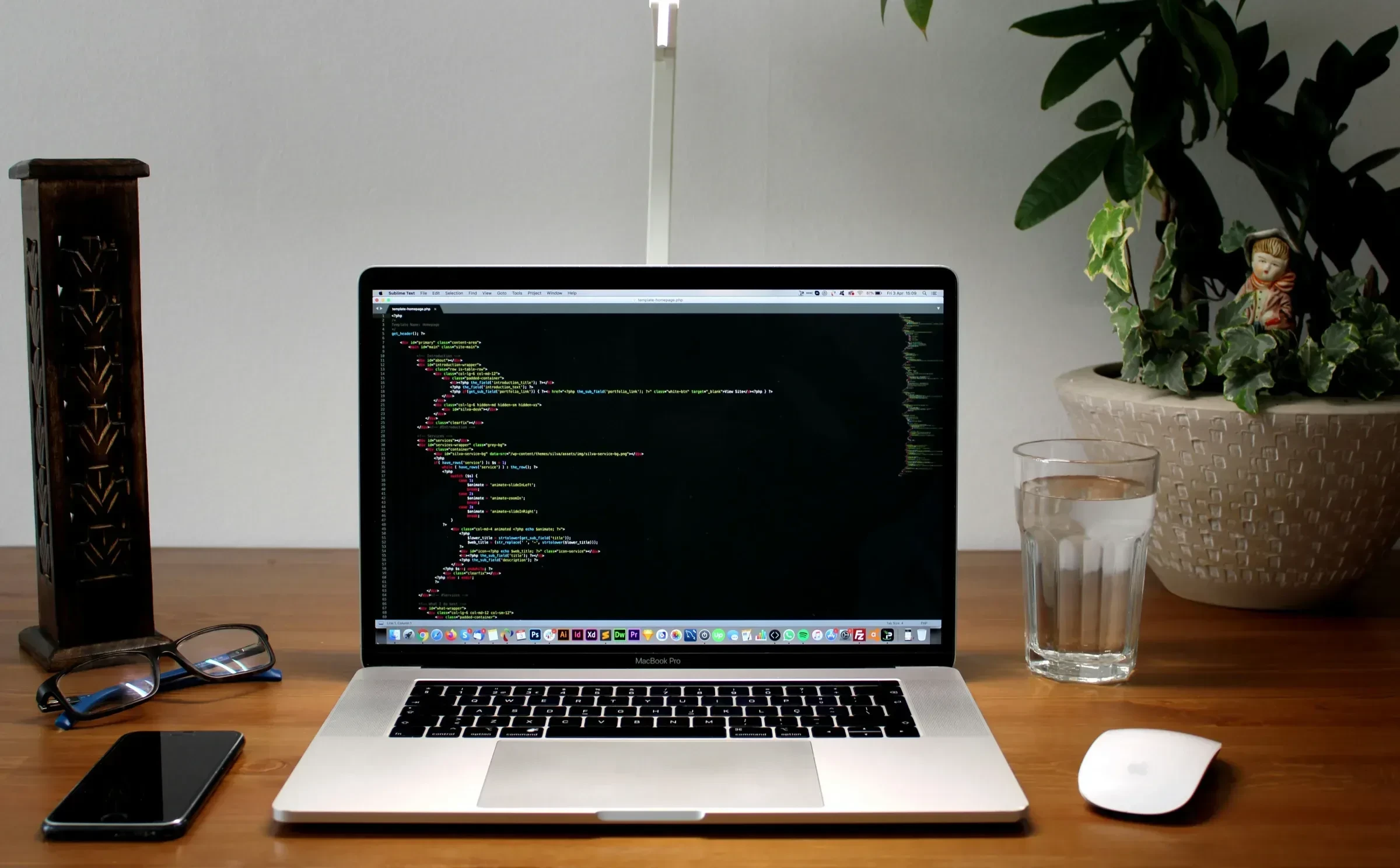 Un ecran de laptop afișând o linie de cod, cu un pahar cu apă lângă, simbolizând decizia unui dezvoltator de a reconstrui totul de la zero.