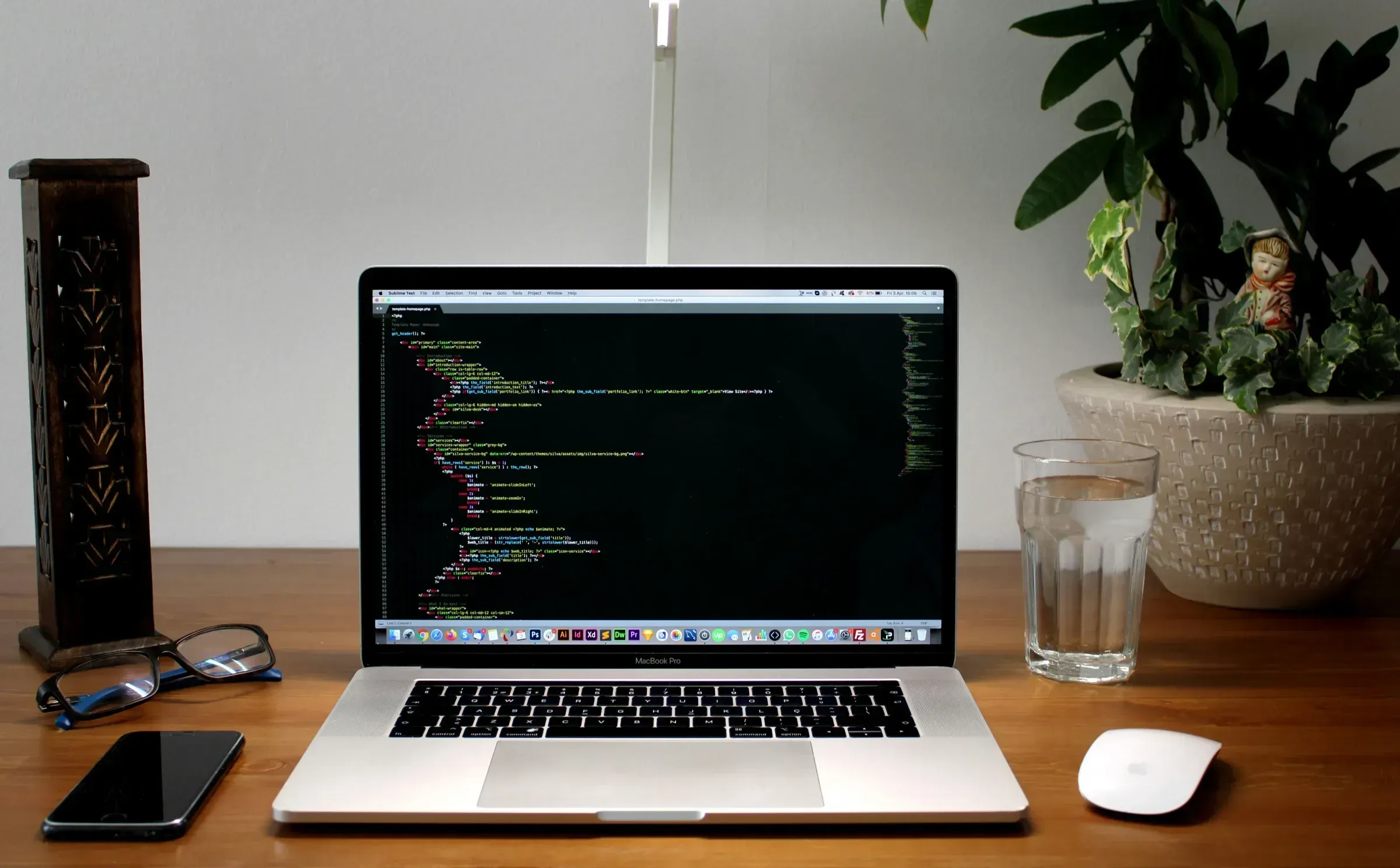 Un ecran de laptop afișând o linie de cod, cu un pahar cu apă lângă, simbolizând decizia unui dezvoltator de a reconstrui totul de la zero.