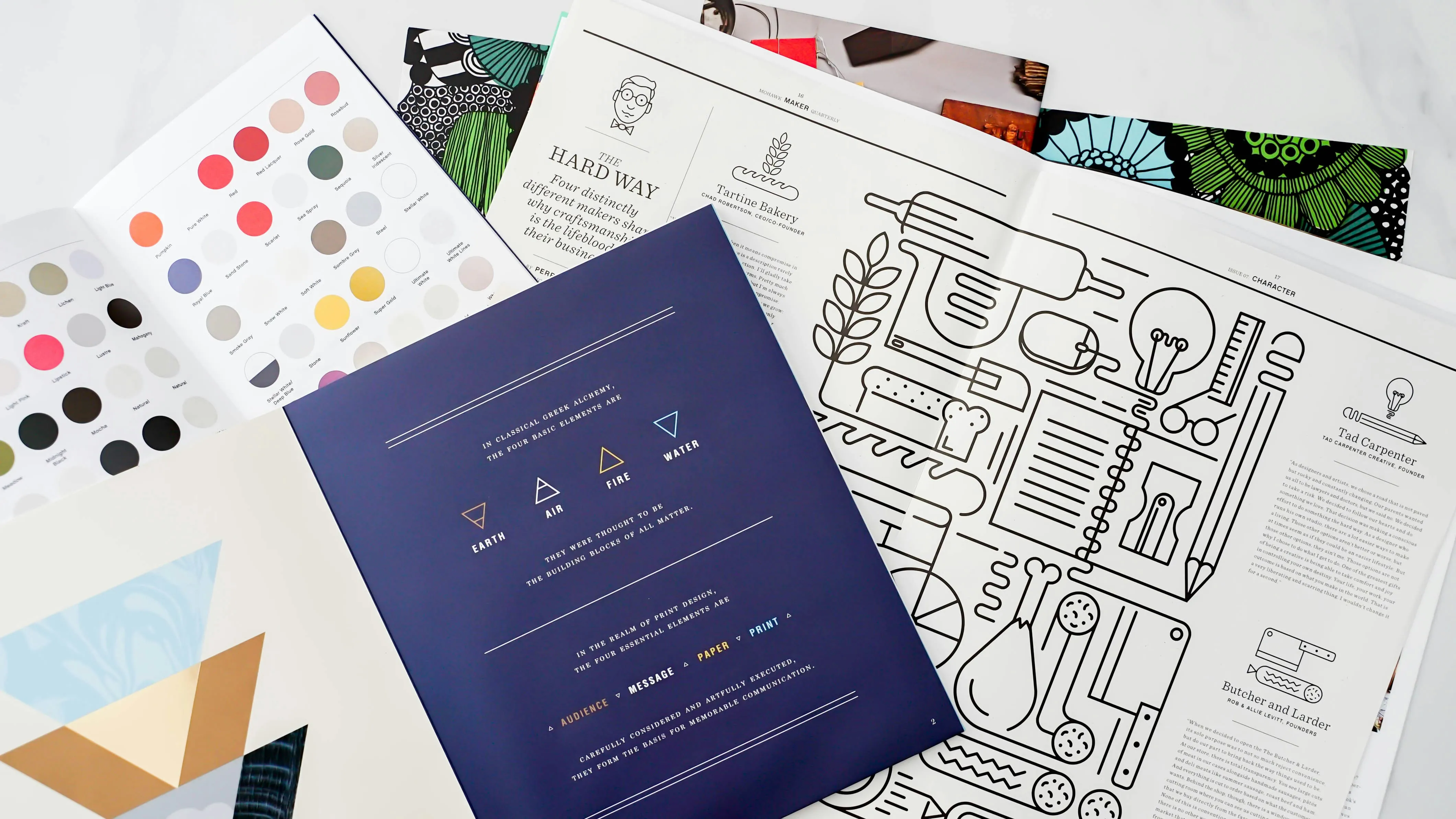 O serie de materiale de branding, inclusiv pliante și palete de culori, așezate pe o masă de lucru, simbolizând elementele care compun o identitate vizuală coerentă.