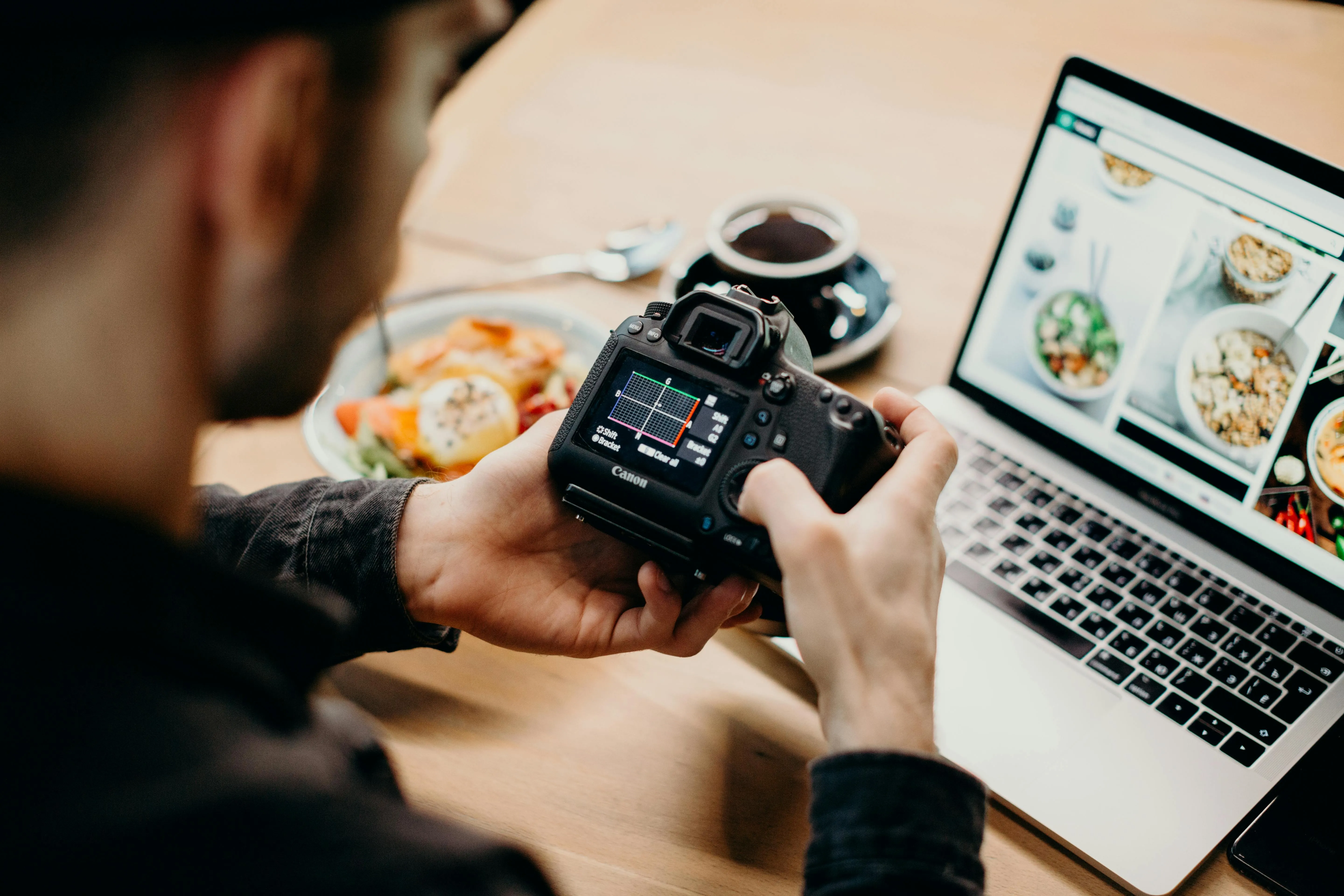 Fotograf profesionist vizualizând un site de portofoliu pe un monitor, ilustrând ideea de site pentru fotograf.